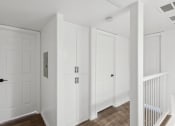 Thumbnail 5 of 15 - the hallway of a home with white doors and a staircase