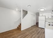 Thumbnail 4 of 15 - a renovated kitchen with white cabinets and white appliances and a white staircase