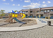Thumbnail 14 of 15 - A playground with a yellow slide and a blue canopy.
