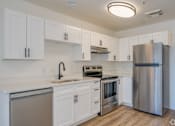 Thumbnail 6 of 15 - a kitchen with white cabinets and stainless steel appliances