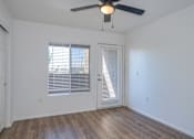 Thumbnail 8 of 15 - an empty living room with a ceiling fan and window