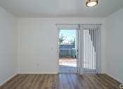 Thumbnail 7 of 15 - an empty living room with a sliding glass door to a backyard