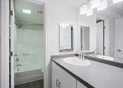 Thumbnail 4 of 32 - a bathroom with a sink and a shower and a mirror