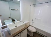 Thumbnail 60 of 94 - A white toilet sits next to a sink in a bathroom.