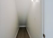 Thumbnail 50 of 94 - A long hallway with wood floors and white walls.