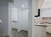 Thumbnail 47 of 94 - A kitchen with white cabinets and a countertop.