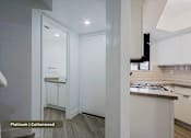 Thumbnail 15 of 51 - A kitchen with white cabinets and a countertop.