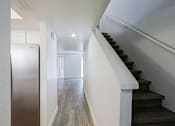 Thumbnail 49 of 94 - A staircase with a white railing leads to a brightly lit room.