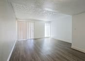 Thumbnail 45 of 94 - A room with wooden flooring and a window with blinds.