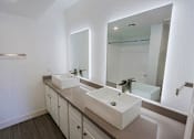 Thumbnail 32 of 94 - A bathroom with two sinks and a large mirror.