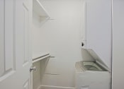 Thumbnail 12 of 32 - a small laundry room with a washer and dryer and a white door
