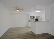 Thumbnail 9 of 32 - an empty apartment with a kitchen and a ceiling fan
