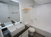 Thumbnail 29 of 94 - A white toilet sits next to a white sink in a bathroom.