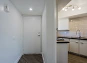 Thumbnail 28 of 94 - A white door in a room with a kitchen in the background.