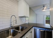Thumbnail 18 of 94 - A kitchen with a stainless steel sink and dishwasher.