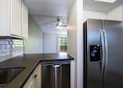 Thumbnail 24 of 94 - A modern kitchen with a stainless steel refrigerator and a dishwasher.