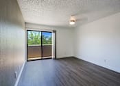 Thumbnail 21 of 94 - A room with a sliding glass door leading to a backyard.