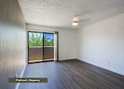 Thumbnail 8 of 51 - A room with a sliding glass door leading to a backyard.