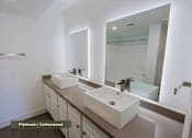 Thumbnail 14 of 51 - A bathroom with two sinks and a large mirror.