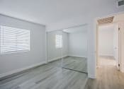 Thumbnail 19 of 32 - an empty bedroom with a mirrored closet and a large window