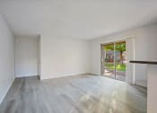 Thumbnail 15 of 32 - an empty living room with a sliding glass door to a patio