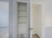 Thumbnail 17 of 32 - an empty room with white closet doors and a wood floor