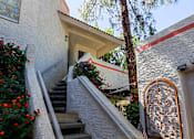 Thumbnail 11 of 94 - A staircase with a wooden handrail and steps leading up to a door with a decorative arch.