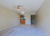 Thumbnail 14 of 94 - A spacious room with a ceiling fan and a carpeted floor.