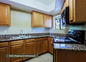 Thumbnail 22 of 51 - A kitchen with wooden cabinets and a granite countertop.