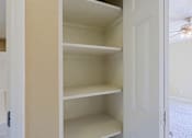 Thumbnail 3 of 94 - A white closet with shelves and a door.