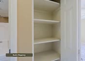 Thumbnail 32 of 51 - Empty white shelves in a pantry.