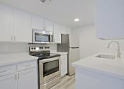 Thumbnail 2 of 19 - a kitchen with white cabinets and stainless steel appliances