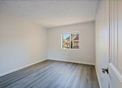 Thumbnail 18 of 36 - A room with a wooden floor and a picture on the wall.