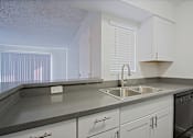 Thumbnail 16 of 36 - A kitchen with a sink and a stove.