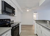 Thumbnail 14 of 36 - A kitchen with black appliances and white cabinets.