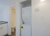 Thumbnail 20 of 36 - A small white washing machine is in a laundry room.