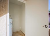Thumbnail 23 of 36 - A white door with a silver handle is open to a room with a white wall and a white fridge.