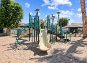 Thumbnail 6 of 18 - a playground with a slide in the middle of the sand
