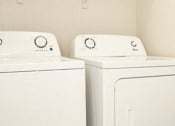 Thumbnail 9 of 14 - two washer and dryers in a white laundry room