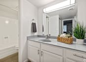 Thumbnail 8 of 16 - a bathroom with white cabinets and a sink and a mirror