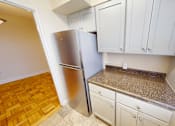 Thumbnail 3 of 28 - A kitchen with a refrigerator, cabinets, and a countertop.