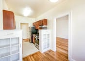Thumbnail 4 of 29 - vacant dining area with view of kitchen and living area with hardwood floors at the frontenac apartments in van ness washington dc