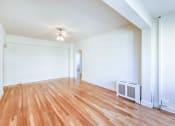 Thumbnail 18 of 29 - vacant living area with hardwood floors and ceiling fan at the frontenac apartments in van ness washington dc