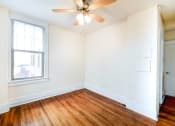 Thumbnail 19 of 21 - vacant living area with large windows, ceiling fan and hardwood flooring at the cortland apartments in washington dc