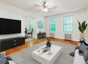 Thumbnail 6 of 17 - living area with sofa, coffee table, credenza, hardwood floors, large windows and view of dining area.