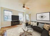 Thumbnail 2 of 19 - living area with sofa, large windows, tv, and hardwood flooring 1401 sheridan apartments in washington dc