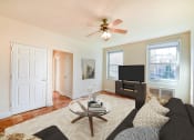 Thumbnail 3 of 19 - living area with sofa, large windows, tv, and hardwood flooring 1401 sheridan apartments in washington dc