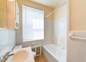 Thumbnail 15 of 19 - bathroom with vanity toilet, tub, and large window  at 1401 sheridan apartments in washington dc