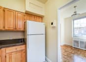 Thumbnail 8 of 19 - kitchen with wood cabinetry, refrigerator, tile flooring and view of dining area  at 1401 sheridan apartments in washington dc