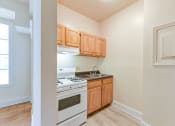 Thumbnail 4 of 39 - kitchen with wood cabinetry, gas range and view of living area at twin oaks apartments columbia heights washington dc